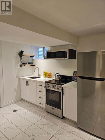 Toronto (Mount Olive-Silverstone-Jamestown) apartment for rent - A kitchen with white cabinets and a stainless steel refrigerator.