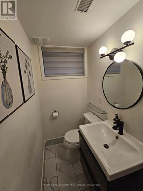 Toronto (Mount Olive-Silverstone-Jamestown) apartment for rent - A bathroom with a toilet, sink, mirror and lighting.