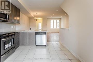 Toronto (Alderwood) townhouse for rent - A kitchen with a stove top oven and a dishwasher.