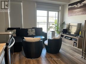 Toronto (Willowdale West) townhouse for rent - A living room with a black wicker chair and a black couch with white cushions.