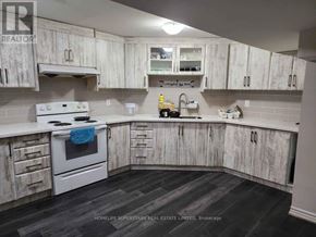 Brampton (Brampton South) apartment for rent - A kitchen with white cabinets and a white stove top oven.