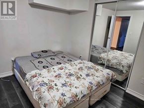 Brampton (Brampton South) apartment for rent - A bedroom with a bed, a mirror, and a wall-mounted shelf.