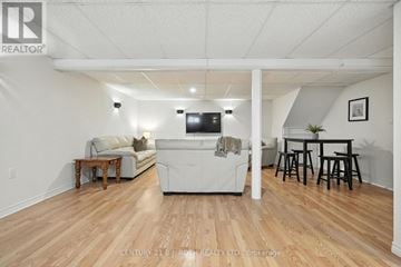 Adjala-Tosorontio (Lisle) apartment for rent - A living room with a white couch and a television.