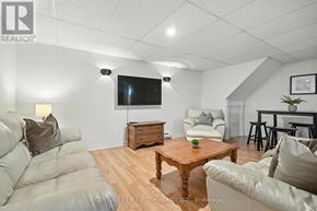 Adjala-Tosorontio (Lisle) apartment for rent - A living room with a grey couch, a wooden coffee table, and a flat screen TV mounted on the wall.