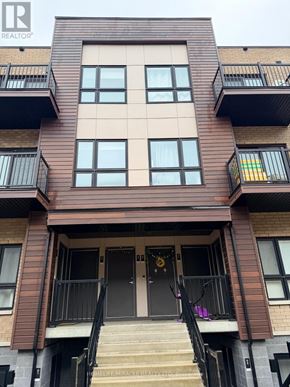 Kitchener townhouse for rent - A brown building with a black railing and a black door.