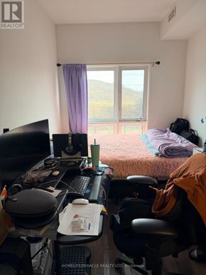 Kitchener townhouse for rent - A room with a desk and a bed with a window in the background.