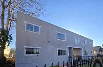 Los Angeles apartment for rent - A grey building with a black fence in front.