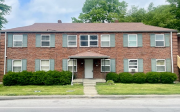 Louisville apartment for rent - A red brick house with green shutters and a grey door.