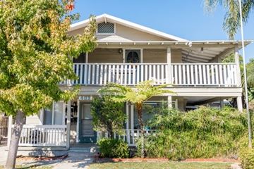 Fullerton apartment for rent - A house with a white porch and a tree in front.
