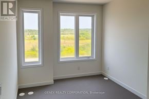 Cobourg townhouse for rent - A room with two windows and a sign that says "REALTOR" on the wall.