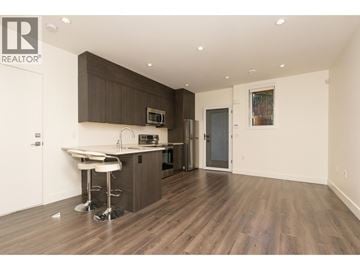 Burnaby apartment for rent - A modern kitchen with dark brown cabinets and white countertops.