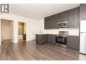 Burnaby apartment for rent - A modern kitchen with dark wood floors and stainless steel appliances.