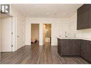 Burnaby apartment for rent - A modern kitchen with dark wood floors and white walls.