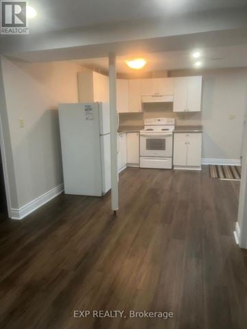 Ajax (Central West) apartment for rent - A kitchen with white appliances and wooden floors.