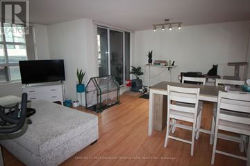 London East (East F) condo for rent - A living room with a grey couch and a television.