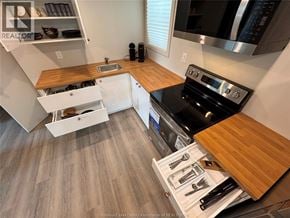 Windsor apartment for rent - A kitchen with a black stove top oven and wooden countertops.
