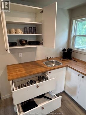Windsor apartment for rent - A kitchen with white cabinets and a wooden counter top.