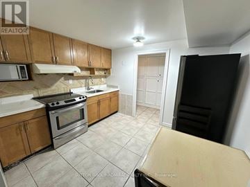 Markham (Middlefield) apartment for rent - A kitchen with wooden cabinets and a black refrigerator.