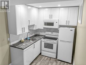 Toronto (Stonegate-Queensway) apartment for rent - A kitchen with white appliances and cabinets.