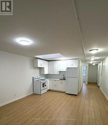 Kitchener apartment for rent - A kitchen with white appliances and wooden floors.