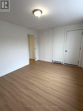 Kitchener apartment for rent - A room with wooden flooring and white walls.