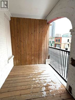 Kitchener apartment for rent - A room with wooden walls and a balcony with a black railing.