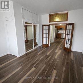 Toronto (Moss Park) apartment for rent - A room with wooden flooring and a mirrored door.