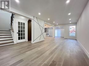 Toronto (Milliken) apartment for rent - A spacious room with wooden flooring and white walls.