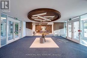 Innisfil condo for rent - A modern office lobby with a large wooden table and chairs.