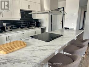 Collingwood condo for rent - A kitchen with a marble countertop and a wooden cutting board.