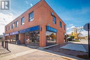 Collingwood condo for rent - A brick building with a blue sign that says "Century 21 Millennium Inc. Brokerage".