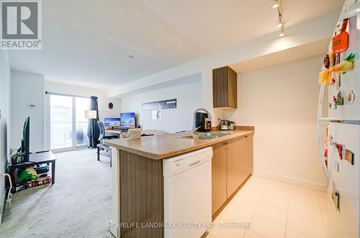 Toronto (Eglinton East) condo for rent - A kitchen with a refrigerator covered in magnets.