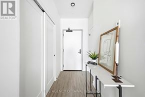 Ottawa condo for rent - A hallway with a white door and a picture frame on a table.