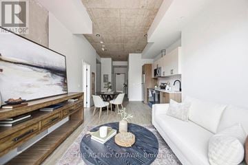 Ottawa condo for rent - A living room with a white couch, a coffee table, and a large painting on the wall.