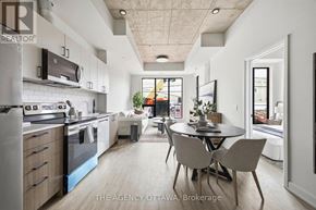 Ottawa condo for rent - A modern kitchen with a dining table and chairs in the middle of the room.