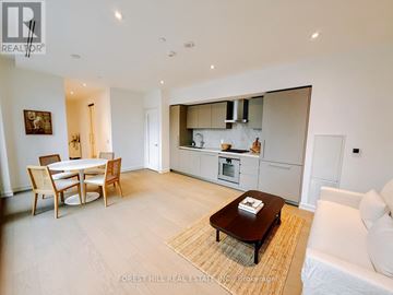 Toronto (Annex) condo for rent - A modern living room with a dining table and a couch.