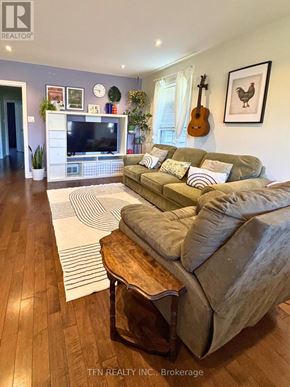 Toronto (Alderwood) apartment for rent - A living room with a couch, a television, and a guitar hanging on the wall.