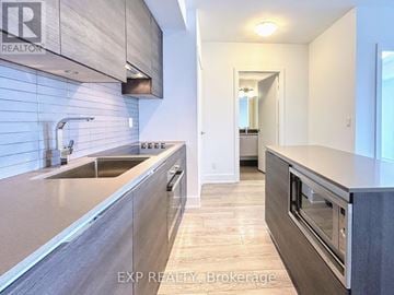 Toronto (Annex) condo for rent - A modern kitchen with a sink and a stove top oven.