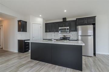Mitchell apartment for rent - A modern kitchen with black cabinets and stainless steel appliances.