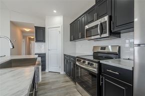 Mitchell apartment for rent - A modern kitchen with black cabinets and stainless steel appliances.