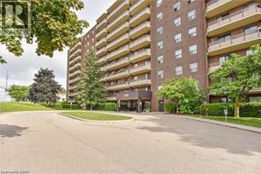 Kitchener condo for rent - A large apartment building with a paved courtyard in front.