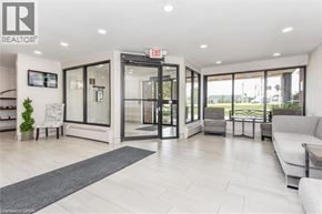Kitchener condo for rent - A well-lit, modern living room with a grey sofa and a glass door leading to a balcony.