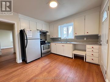 Toronto (Newtonbrook East) apartment for rent - A kitchen with white cabinets and a black fridge.