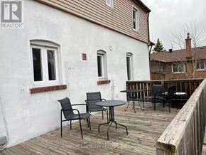 Toronto (Newtonbrook East) apartment for rent - A white house with a wooden deck and patio furniture.