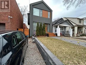 Toronto (Danforth Village-East York) apartment for rent - A house with a grey front and a red brick wall to the left.