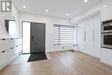 Toronto (Danforth Village-East York) apartment for rent - A modern kitchen with white cabinets and a black door.