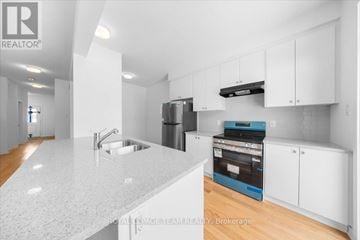 Ottawa townhouse for rent - A kitchen with white cabinets and a granite countertop.