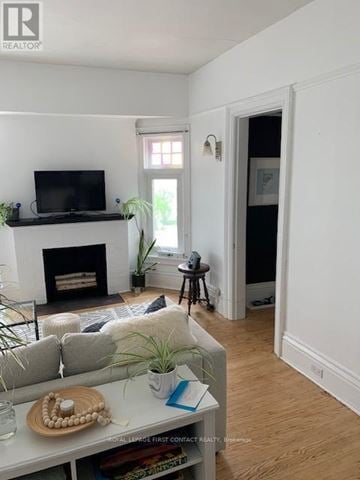 Barrie (City Centre) triplex for rent - A living room with a fireplace and a television on the wall.