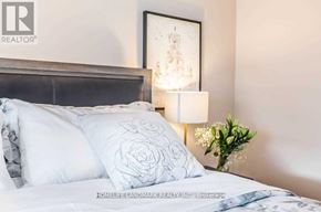Richmond Hill (Crosby) apartment for rent - A bed with a white pillow that has a rose design on it.