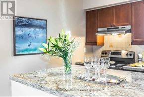 Richmond Hill (Crosby) apartment for rent - A kitchen counter with a vase of flowers, a plate with glasses, and a painting on the wall.